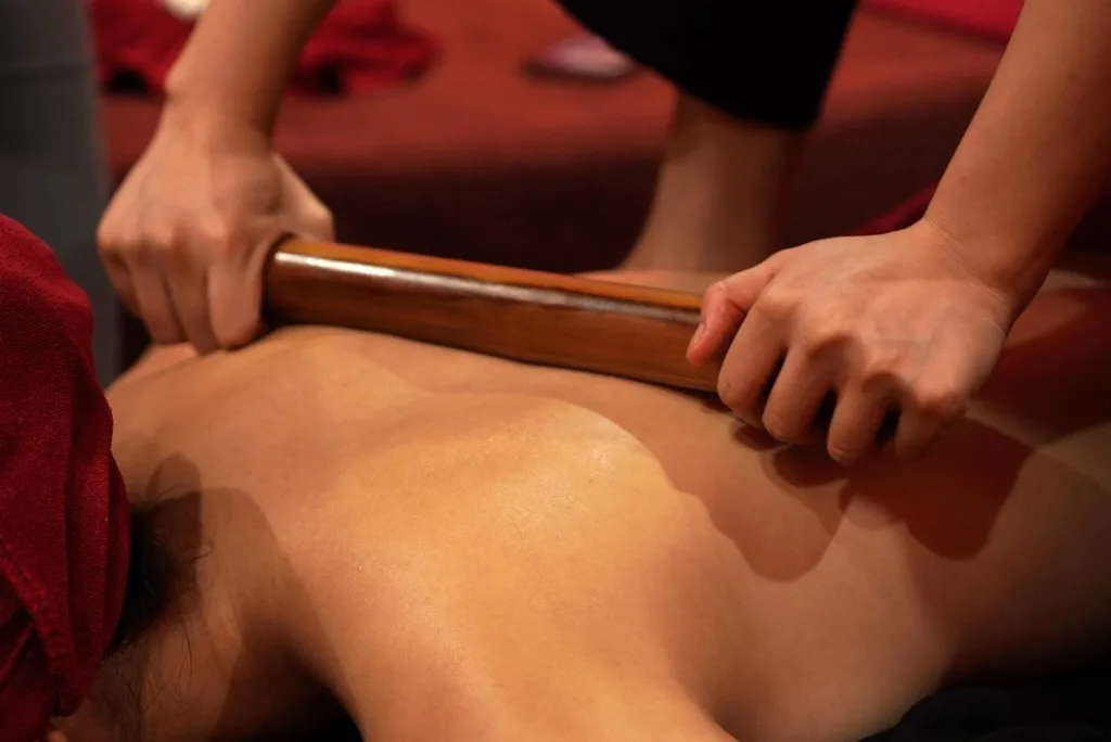 Warmed bamboo rod rolled along the back muscles during a bamboo massage